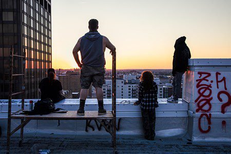 Two urban explorers look out over downtown St. Louis from the roof of the Railway Exchange Building.